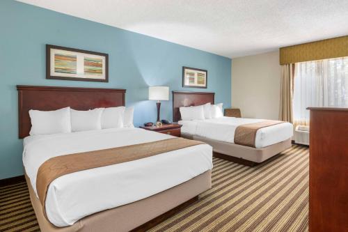 two beds in a hotel room with blue walls at Best Western Plus Sikeston in Sikeston