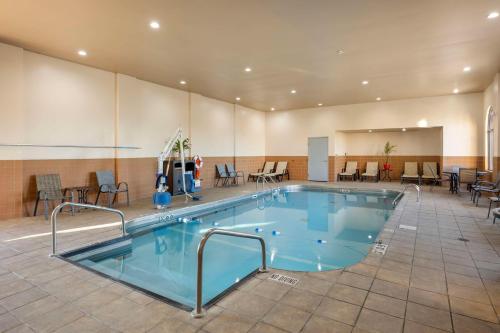 a large swimming pool in a room with tables and chairs at Best Western Plus Sikeston in Sikeston