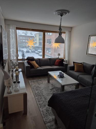 a living room with a couch and a table at Lapland Cozy Apartment in Rovaniemi