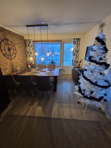 a living room with a christmas tree and a table at Lapland Cozy Apartment in Rovaniemi