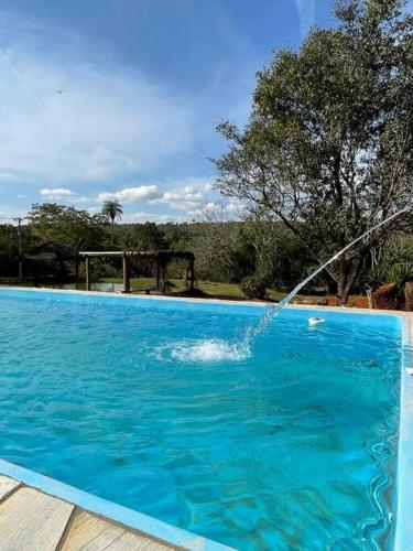 a swimming pool with a water hose in the air at Sítio mini fazenda em Lagoa Santa in Lagoa Santa