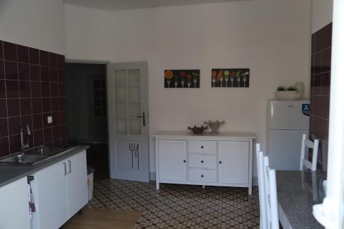 a kitchen with white cabinets and white appliances at Hostel Rossio Alcobaça in Alcobaça