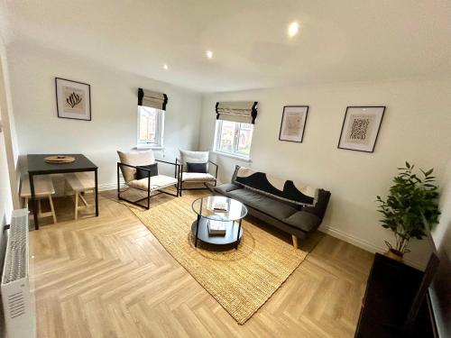 a living room with a couch and a table at Brand new City centre apartment with parking in Cardiff