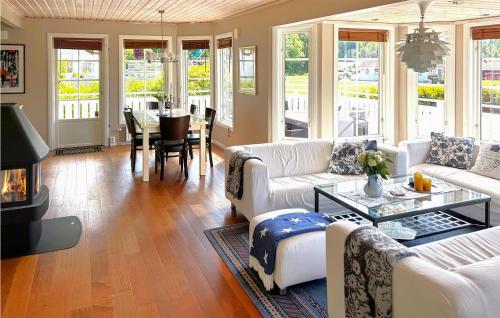 a living room with white couches and a table at Amazing Home In Strömstad With Sauna in Lökholmen