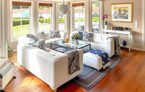 a living room with white couches and a table at Amazing Home In Strömstad With Sauna in Lökholmen