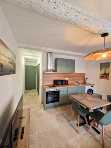 une cuisine avec une table et une salle à manger dans l'établissement La Verrerie, à Arles