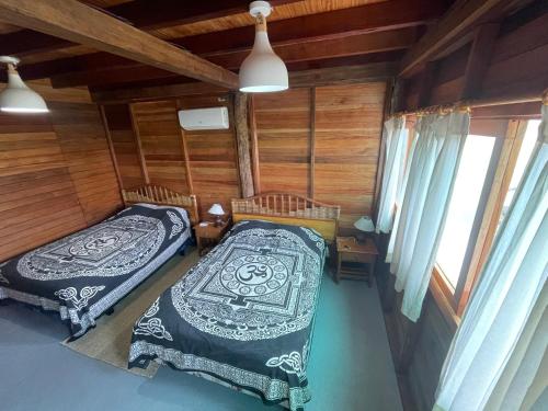 a bedroom with two beds in a wooden cabin at Galapagos Chalet in Puerto Ayora