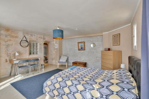 a bedroom with a bed and a table and a kitchen at Appartement quartier Vaugueux in Caen