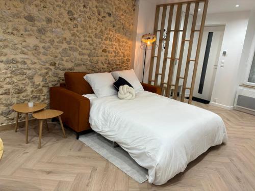 a bedroom with a large bed and a stone wall at Chez Sof&Jé in Brie-Comte-Robert
