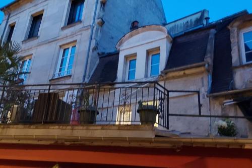 un bâtiment avec deux plantes en pot sur un balcon dans l'établissement Appartement quartier Vaugueux, à Caen