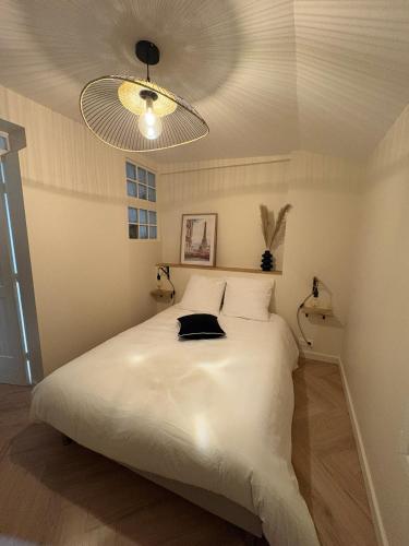 une chambre avec un grand lit blanc avec un plafond dans l'établissement Chez Sof&Jé, à Brie-Comte-Robert