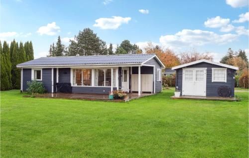 a small blue house with a large yard at Nice Home In Bogø By With Wifi in Bogø By