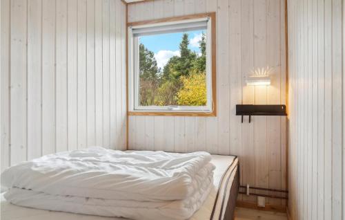 a bed in a room with a window at Nice Home In Bogø By With Wifi in Bogø By