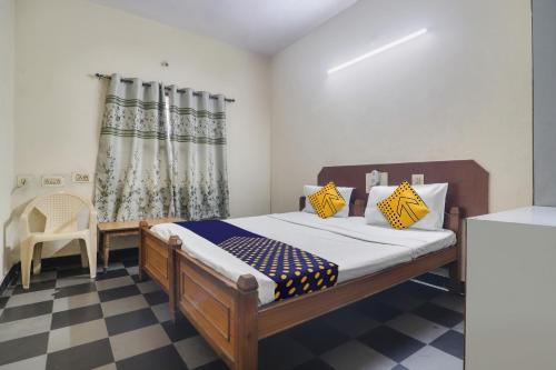 a bedroom with a bed and a chair and curtains at SPOT ON New Balaji Residency in Hyderabad