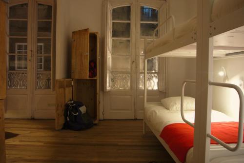 a small room with a bed and a door at Slow City Hostel Pontevedra in Pontevedra