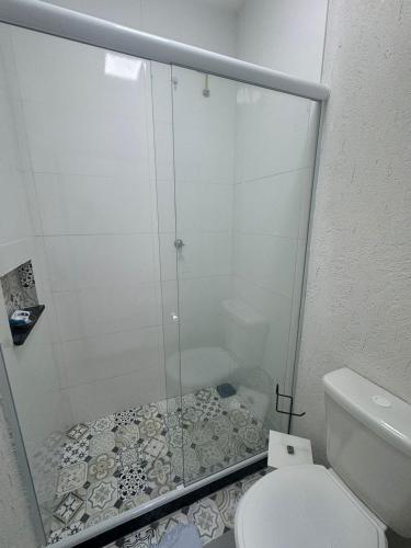 a bathroom with a shower and a toilet at MAHALO 1004 Suites in Maricá