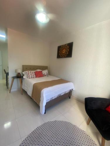 a bedroom with a bed in a room at MAHALO 1004 Suites in Maricá