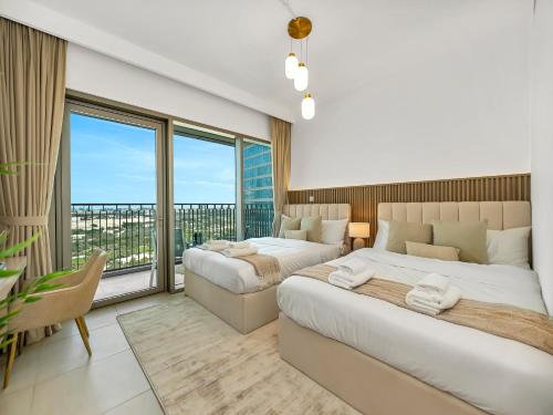 a bedroom with two beds and a large window at Blissful Stays - Luxury Two Bedroom Apartment at Downtown Views II- 5 min walk to Dubai Mall, Burj Khalifa with Infinity Pool in Dubai