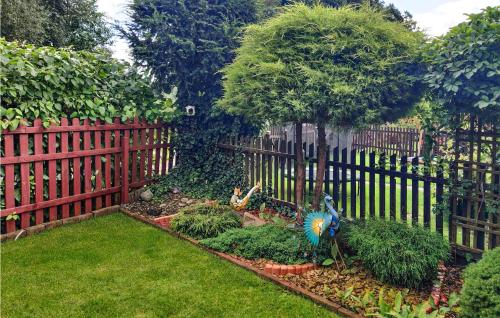 a fence with a garden in front of a yard at 2 Bedroom Amazing Home In Wilcze in Wilcze
