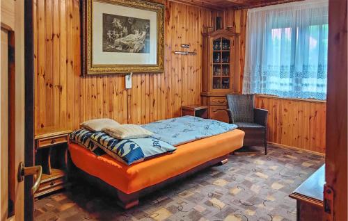 a bedroom with a bed and a chair in it at 2 Bedroom Amazing Home In Wilcze in Wilcze