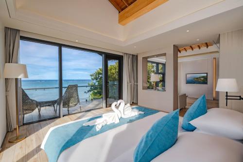 a bedroom with a bed with a view of the ocean at Palau Sunrise Seaview Landison Retreat in Melekeok