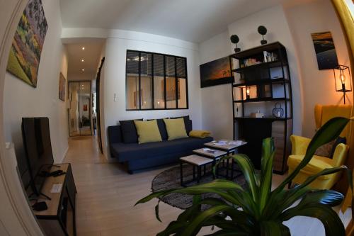 un salon avec un canapé bleu et une table dans l'établissement Le Yellow Corner Voironnais, à Voiron