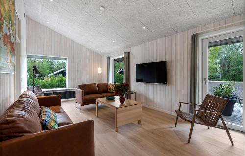 a living room with a couch and a tv at Gorgeous Home In Oksbøl With Sauna in Oksbøl