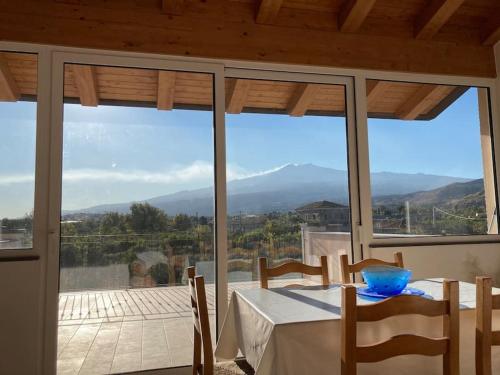a dining room with a table and a view of the mountains at Villetta Alcantara Apartment in Calatabiano