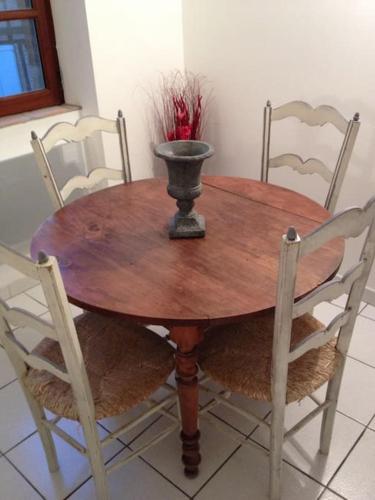 une table en bois avec des chaises et un vase. dans l'établissement Appartement Centre Historique 2 personnes, à Albi