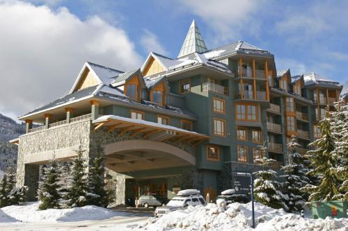 a large building in the snow with a car parked in front at Renovated 1Bed-1Bath in Village with Pool, Hot Tub, and Sauna in Whistler