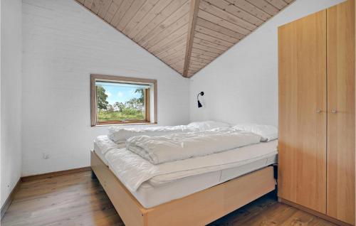 a bed in a room with a window at Four-Bedroom Holiday Home In Blavand in Blåvand