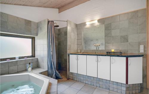 a bathroom with a tub and a sink at Four-Bedroom Holiday Home In Blavand in Blåvand