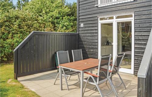 a wooden table and chairs on a patio at Apartment Norre Nebel 306 in Nørre Nebel