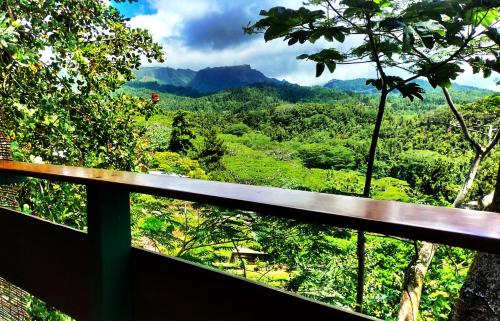 a balcony with a view of a forest at L'Auberge Polynésienne in Tevaitoa