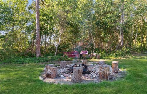 a fire pit in the middle of a yard with trees at 3 Bedroom Stunning Home In Rødby in Rødby