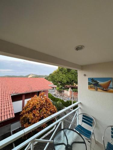 a balcony with chairs and a view of a house at Village Hospedagens in Natal