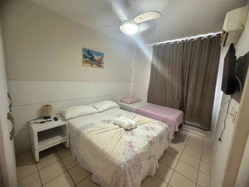 a small room with two beds and a window at Village Hospedagens in Natal