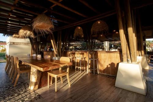 a restaurant with a wooden table and a bar at Spacious Bright & Airy Penthouse G at Playa Venao in Playa Venao