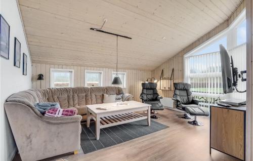 a living room with a couch and a table at Holiday Home Tarm 49 in Hemmet