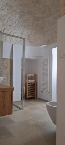 a white bathroom with a sink and a tub at Trullo Ritunno in Locorotondo