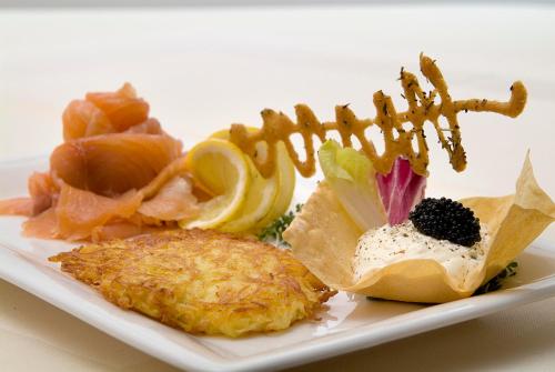 a plate of food with fish and other foods at Hotel Restaurant Roemer in Merzig