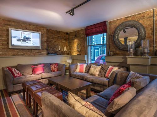 a living room with couches and a table at The Admiral Rodney Hotel, Horncastle, Lincolnshire - The Coaching Inn Group in Horncastle