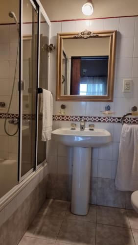 ein Badezimmer mit Waschbecken, Dusche und Spiegel in der Unterkunft Casa Calandria in Federación