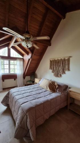 a bedroom with a ceiling fan and a bed at Casa Calandria in Federación