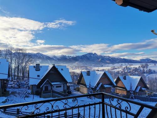 a view of a town in the snow from a balcony at Willa WIDOKOWA CUDZICH in Zakopane