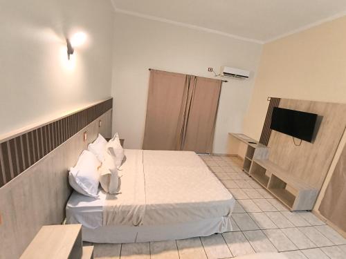 a hotel room with a bed and a television at Palo Rosa Lodge in Puerto Iguazú
