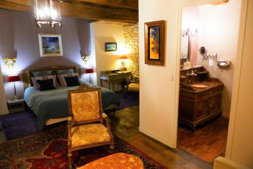 a bedroom with a bed and a desk and a chair at Manoir Desnachez in Taupont