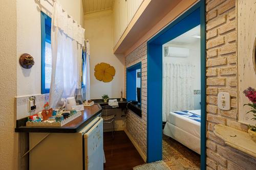 a room with a bed and a blue doorway at Pouso Caminho das Artes in Cunha