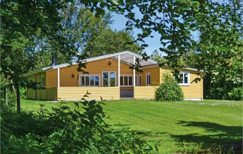 a yellow house on a grassy field with trees at Holiday Home Sydskrænten Oksbøl in Oksbøl
