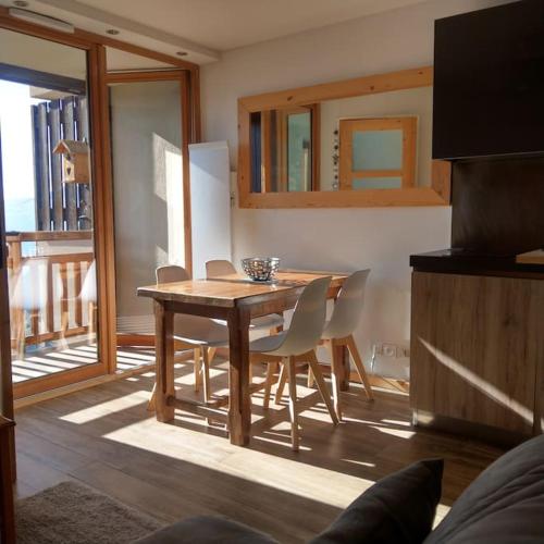 une salle à manger avec une table et des chaises en bois dans l'établissement Appartement entièrement rénové, vue exceptionnelle, à Huez